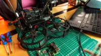 Drone assembly on a desk with laptop and tools, capturing modern tech.