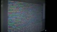 Close-up of colorful programming code on a blurred computer monitor.