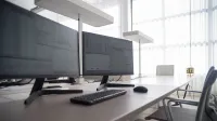 Stylish contemporary office featuring multiple computer monitors and ergonomic chairs.