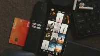 Flat lay of a smartphone, remote control, credit card, and gadgets for a tech-savvy lifestyle.