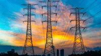 High voltage power lines against a dramatic sunset sky, symbolizing energy and technology.