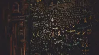 Chalkboard filled with complex cybersecurity and hacking symbols in colorful chalk.