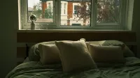 Acogedor dormitorio con almohadas suaves y una vista de ventana en otoño. ambiente acogedor.