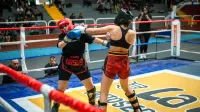 Intense kickboxing match featuring two female athletes in a boxing ring.