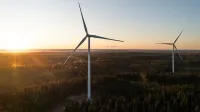 Turbinas de viento en un entorno rural con la puesta de sol detrás