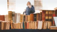 Una colección de libros antiguos en exhibición en un mercado al aire libre en Rovereto, Italia.