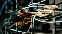 Varios cables enredados conectados al sistema cerca de cajas de metal negro en la sala de servidores