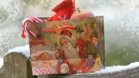 Bolsa de regalo navideña festiva con bastones de Papá Noel y Candy, colocado sobre una superficie de madera espolvoreada.
