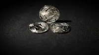 Close-up of three Ethereum coins on a dark background, showcasing digital currency themes.