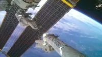 El astronauta de la NASA, Anil Menon, monta el brazo robótico Canadarm2 para comenzar la instalación de una matriz solar desplegable en la estructura de armadura de puerto de la Estación