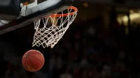 A basketball going through the hoop during a fast-paced game, capturing the excitement of the sport.