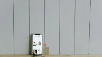 A smartphone displaying an ecommerce site with a credit card, set on a wooden surface, depicting online shopping.