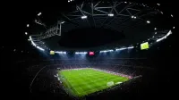 Vista aérea de un partido de fútbol nocturno en Budapest. Estadio iluminado lleno de fans añade un ambiente dramático.