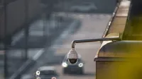 Cámara CCTV con vistas a una calle concurrida con coches en movimiento, capturando la vigilancia urbana.