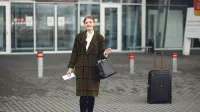 Mujer de moda con equipaje llega al aeropuerto listo para viajar.