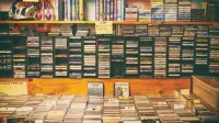 Una exhibición nostálgica de cintas de casete y CD en una tienda de discos vintage.