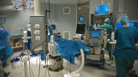 Un moderno quirófano con personal médico realizando cirugía, equipado con instrumentos de alta tecnología.