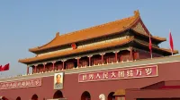 Historic Tiananmen Gate under blue skies in Beijing, China, symbolic and tourist landmark.
