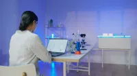 Científica que estudia estructuras químicas en una computadora portátil en un moderno laboratorio.