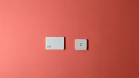 Teclas simples de teclado Ctrl y C sobre un fondo coral, que representa la función de copia.
