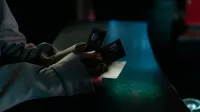 Imagen de mal humor de una persona con entradas de cine por la noche, destacando la anticipación de una noche de cine.