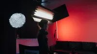 Un director en un estudio con iluminación y equipamiento, creando una atmósfera cinematográfica.