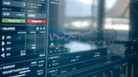 Primer plano de una pantalla digital que muestra gráficos de negociación de acciones y valores de criptomonedas. Ideal para temas de finanzas y tecnología.