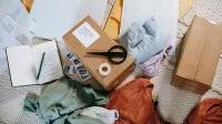 Desde arriba de varias cajas de cartón y etiquetas cerca de la ropa en la superficie en la habitación