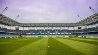 Explore un estadio de fútbol con cielos despejados y hierba prístina, perfecto para cualquier evento deportivo.