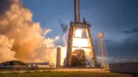 A dramatic shot of a SpaceX rocket launch against a colorful dusk sky, depicting power and technology.