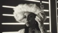 Elegant woman in vintage attire with fur hat and lace gloves holding a microphone.