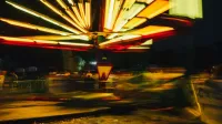 Movimiento borroso de un paseo en una taza de té iluminado en un carnaval nocturno.