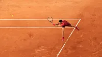 Novak Djokovic returning a serve with his backhand at the 2024 French Open (Roland-Garros), during his first round match against Pierre-Hugues Herbert (win 6/4, 7/6, 6/4) on court
