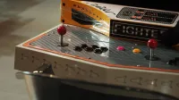 Close-up of a vintage arcade game control panel with joysticks and buttons.