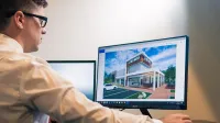 Architect evaluating a building design on a computer screen in an office setting.