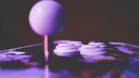 Una vibrante imagen de primer plano de un joystick de arcade y botones, capturando un ambiente de juego retro.