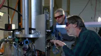 Los físicos del NIST Steve Jefferts (primer plano) y Tom Heavner con el reloj atómico de la fuente del cesio NIST-F2, un nuevo estándar civil de tiempo para los Estados Unidos.