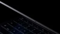 La computadora portátil Googlebook se abre lentamente, vista desde un ángulo bajo que muestra el teclado y la bisagra.
