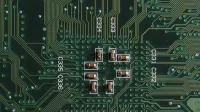 Explore el intrincado diseño y los componentes en una placa de circuito verde con condensadores y vías.