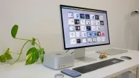 Una estación de trabajo elegante y moderna con dispositivos Apple y un toque de vegetación, ideal para los entusiastas de la tecnología.