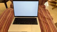 Un MacBook Pro plateado de 14 pulgadas 2021 con un fondo blanco liso.