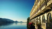 Stunning view of a lakeside palace in Udaipur, reflecting its intricate architecture on the serene water.