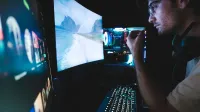 Un hombre con anteojos se centró en múltiples pantallas, mostrando la configuración de la tecnología moderna.
