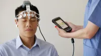 Profesional de la salud que realiza un examen de EEG utilizando un dispositivo BrainScope en un paciente masculino.