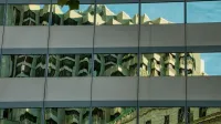 Reflexión del paisaje urbano sobre las ventanas de la fachada del edificio en San Francisco, CA.