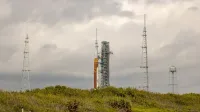 Cohete de la NASA en la plataforma de lanzamiento rodeado de antenas contra un cielo nublado.