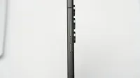 Disparo de perfil lateral minimalista de un smartphone delgado moderno que destaca sus lentes de cámara.