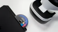 Vista aérea de la consola de PlayStation, auriculares VR y disco de juego sobre un fondo blanco.