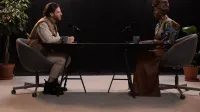 Dos personas que tienen una conversación atractiva en un estudio con micrófonos.