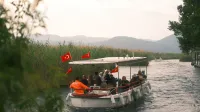 Un grupo disfruta de un tranquilo paseo en bote en un sereno río turco adornado con banderas nacionales.